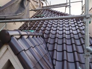 柏市の外壁塗装と屋根塗装の現場で屋根瓦の塗装を濃茶色で塗装しています。