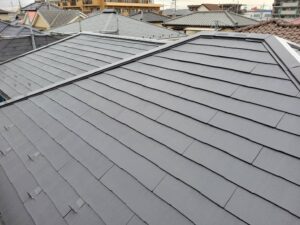 松戸市の屋根塗装現場です。上塗りを黒系色で塗装しています。